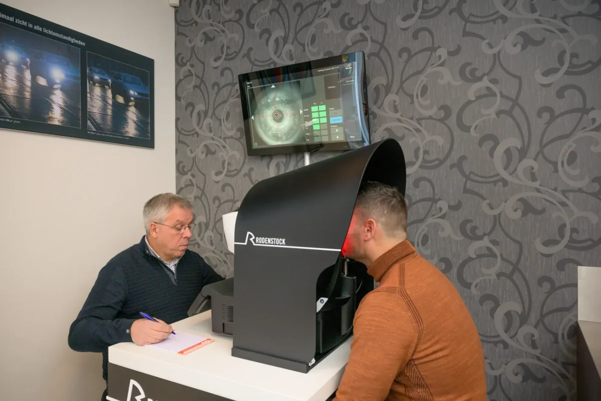 Opticien Cris maakt een DNEye-scan van de ogen van een klant