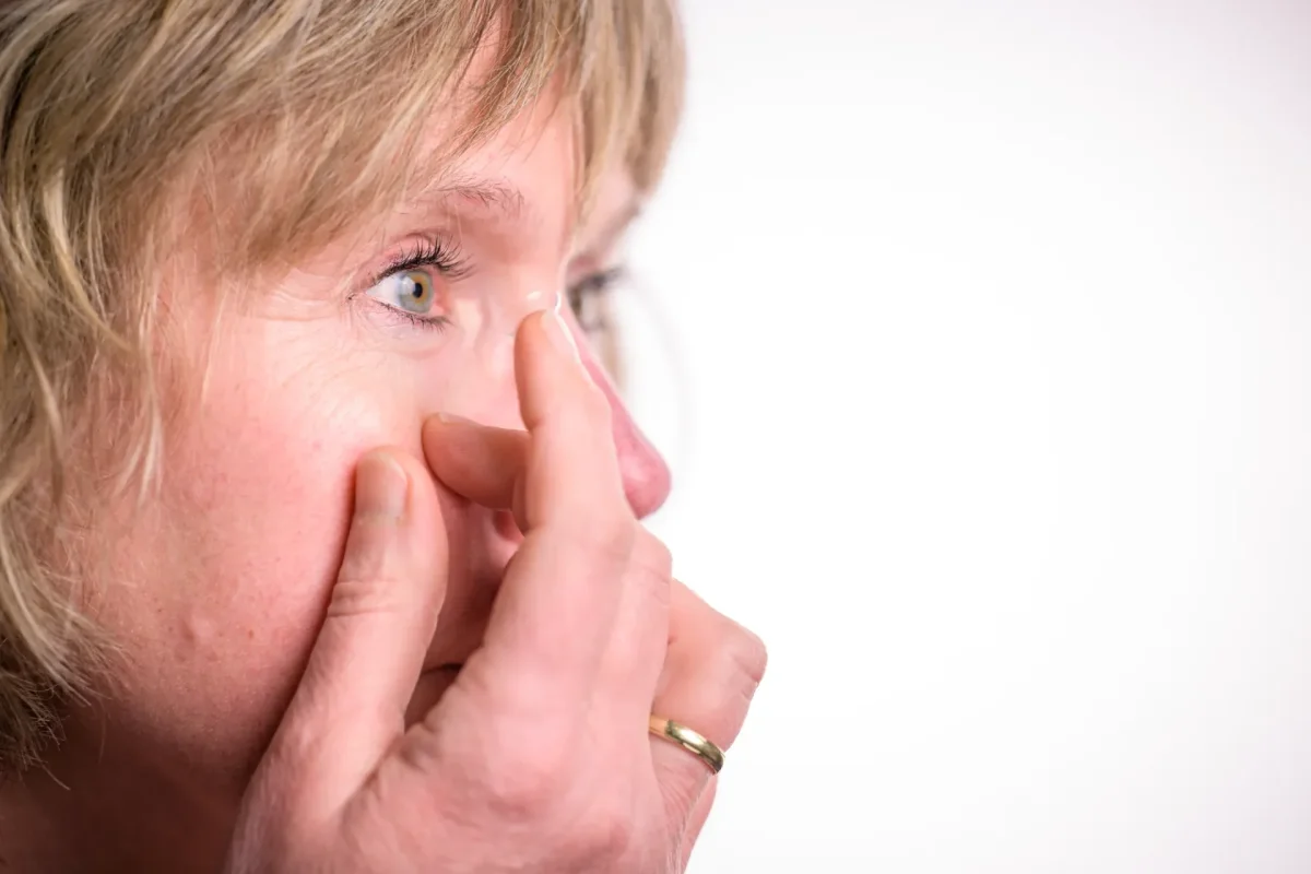 Vrouw wrijft in haar oog omdat haar contactlenzen droog aanvoelen