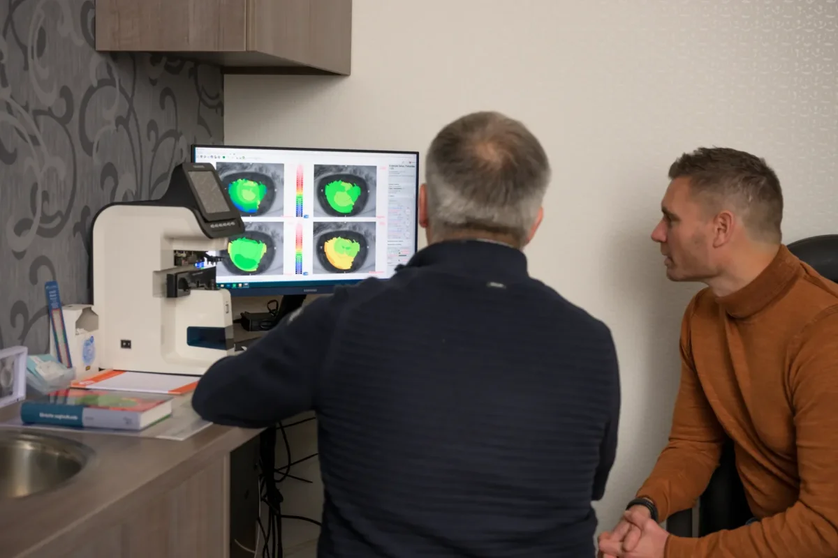 Opticien Cris bespreekt de uitslag van de DNEye-scan op het scherm met een klant