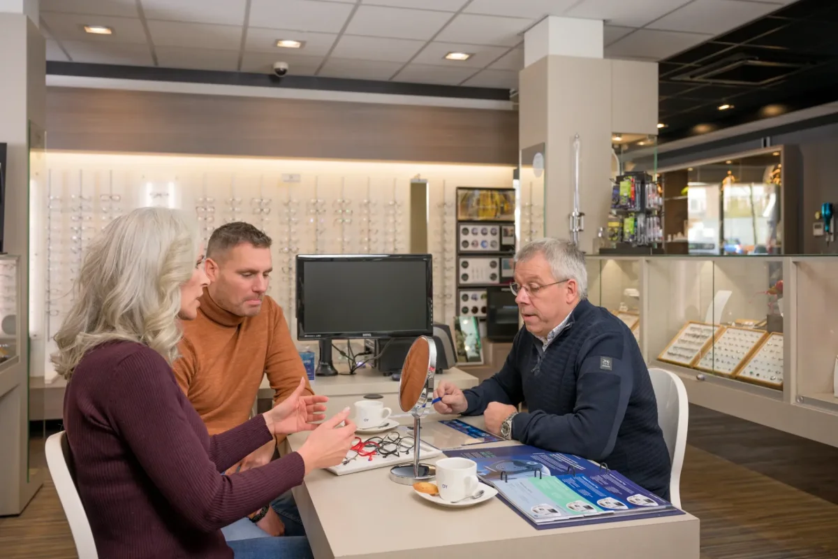 Opticien Cris in gesprek aan tafel met een klant en haar partner in de winkel van Von Oy