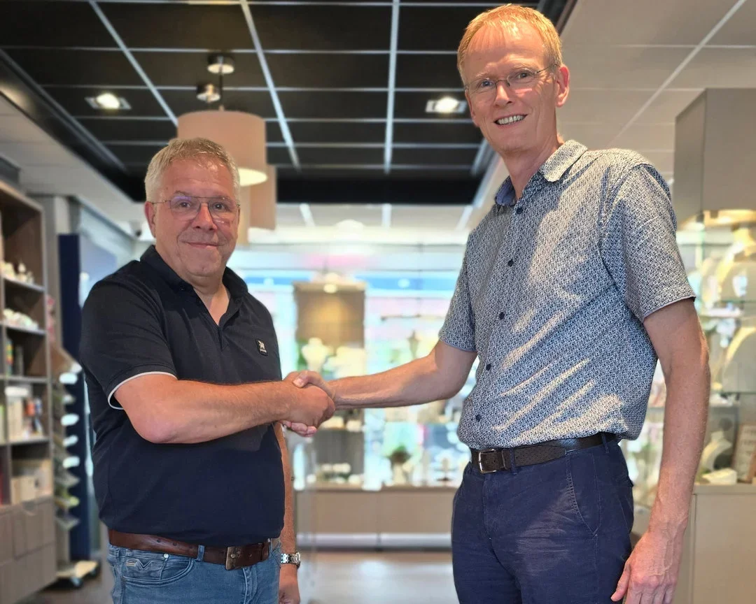 Links opticien Cris van Von Oy, rechts huisarts Arntzen. Ze geven elkaar een hand in de winkel, bij de actie 300 brillen voor Zambia