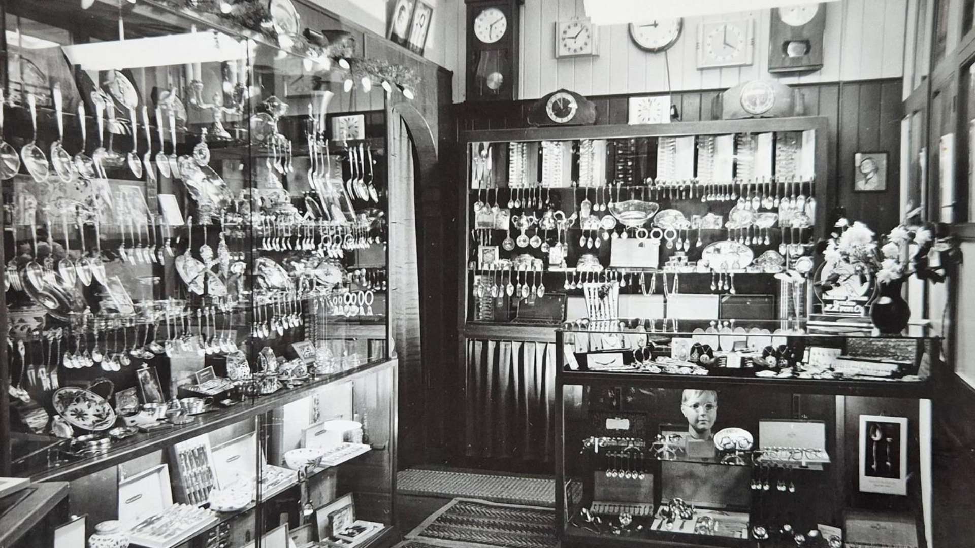 Zwart-witfoto van de oude winkel van Von Oy met vitrines vol brillen en klokken